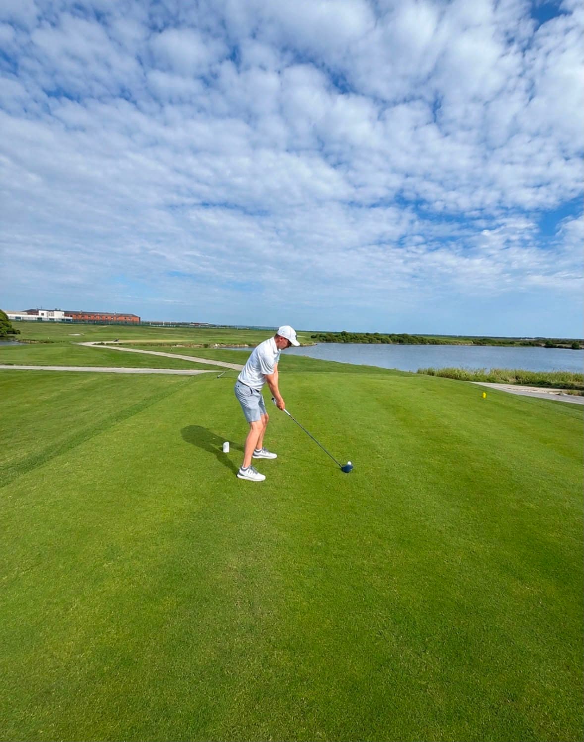 A golfer mid-round with the sea at Stokes Bay behind