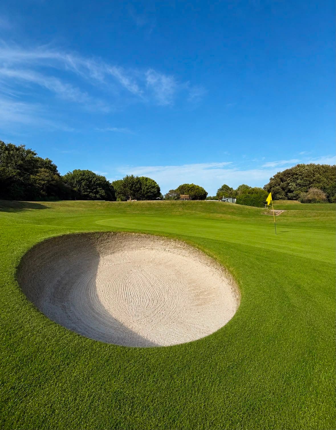 The 18th green with its guarding bunker in the foreground
