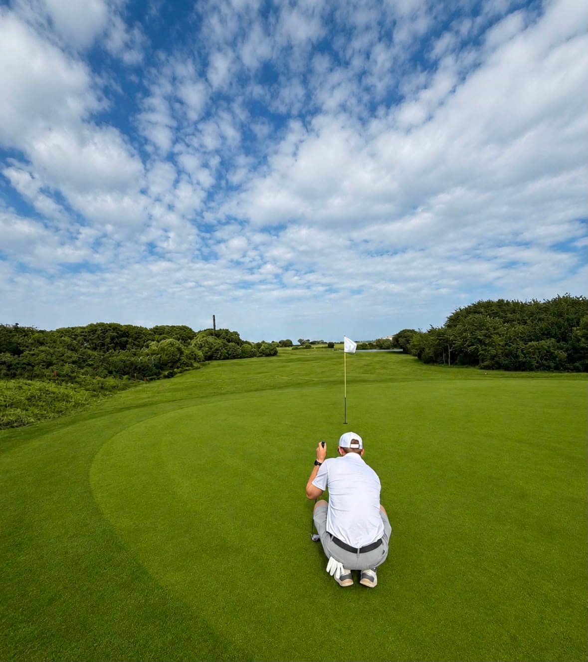 A golfer lining up a putt on one of the eleven greens